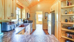 Una cocina moderna con armarios de madera, encimeras de granito y electrodomésticos de acero inoxidable.