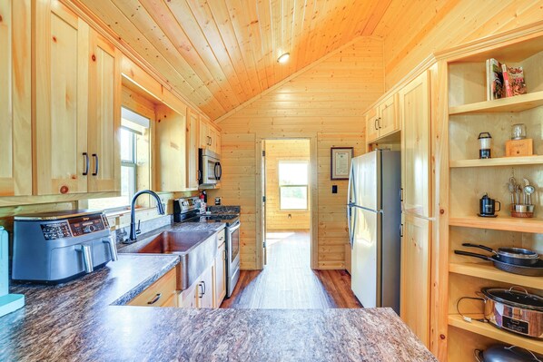 Une cuisine moderne avec des meubles en bois, des plans de travail en granit et des appareils électroménagers en acier inoxydable.