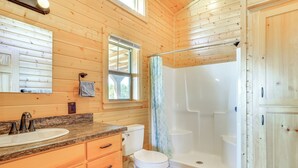A wooden cabin bathroom with a sink, toilet, and shower. - 17 Mi to Tarleton State: Mtn-view Hideaway! (Stephenville)