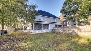 A two-story house with a covered patio and a fenced backyard. - 1 Mi to Pier: Screened Patio at Murrells Inlet Apt (Murrells Inlet)