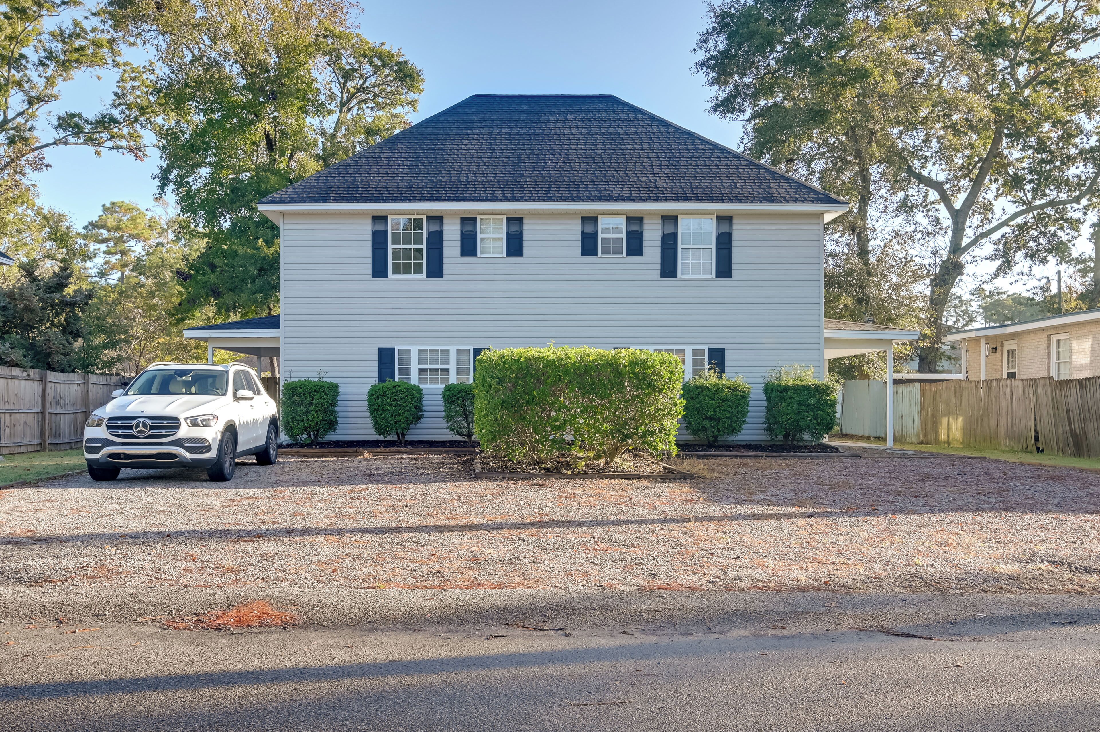 A two-story house with a driveway and a parked car.