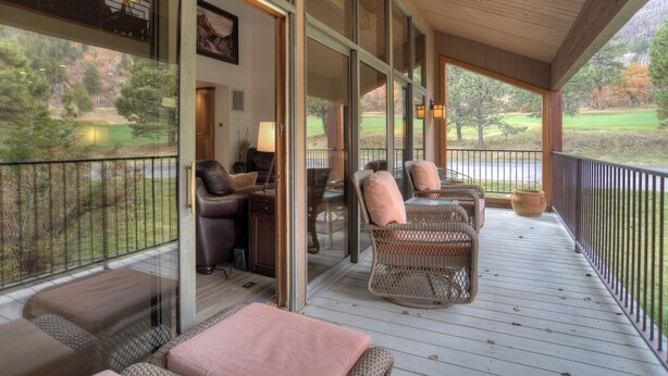 A covered porch with wicker furniture, a desk, and a chair. - High Mountain Home | AC, Pool, Hot Tub, Golf & Ski (Durango)