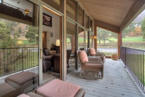 A covered porch with wicker furniture, a desk, and a chair. - High Mountain Home | AC, Pool, Hot Tub, Golf & Ski (Durango)
