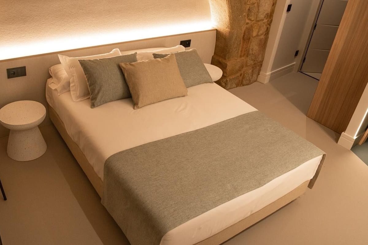 A modern bedroom with a bed, bedside table, and a chair.