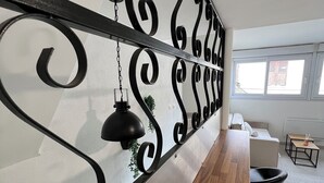A modern kitchen with a wooden countertop, black pendant lights, and a decorative metal partition. - Beautiful T3 bis duplex near town center (Sens)