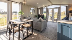A spacious living area with a dining table, sofa, and a view of the outdoors. - Host Stay Riverwood Ashdown Retreat (Pickering)