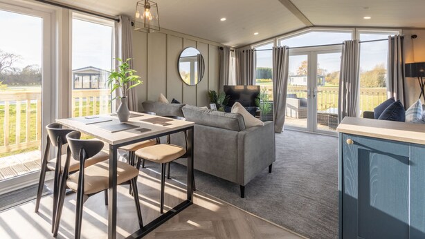 A spacious living area with a dining table, sofa, and a view of the outdoors. - Host Stay Riverwood Ashdown Retreat (Pickering)