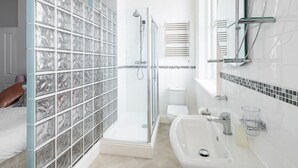 A modern bathroom with a glass shower enclosure, a white sink, and a toilet. - Host Stay Egton Bridge at the Sandbeck (Whitby)