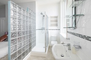 A modern bathroom with a glass shower enclosure, a white sink, and a toilet. - Host Stay Egton Bridge at the Sandbeck (Whitby)