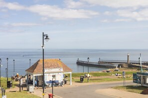 A coastal scene with a pier, a small gazebo, and a signboard. - Host Stay Egton Bridge at the Sandbeck (Whitby)