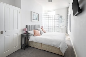 A bedroom with a bed, bedside table, and a TV mounted on the wall. - Host Stay Egton Bridge at the Sandbeck (Whitby)