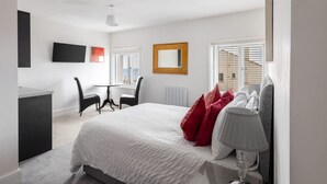 Et moderne hotelværelse med en stor seng, et skrivebord og en stol.