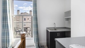 A modern kitchen with a built-in sink, dark cabinets, and a marble countertop. - Host Stay Grosmont at the Sandbeck (Whitby)
