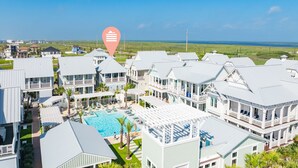 A resort with multiple buildings, a swimming pool, and a view of the ocean.