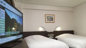 Habitación de hotel con dos camas, un televisor mostrando una imagen panorámica y un cuadro en la pared.