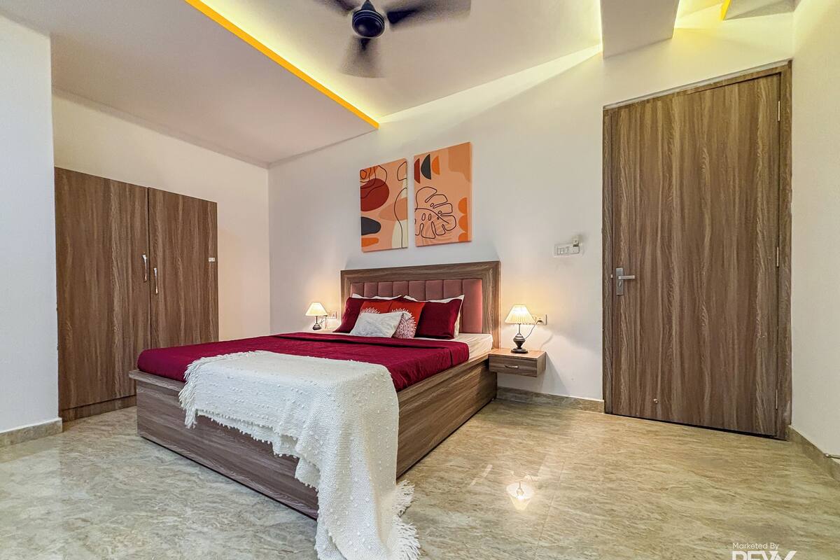 A bedroom with a bed, nightstands, a ceiling fan, and wooden wardrobes.