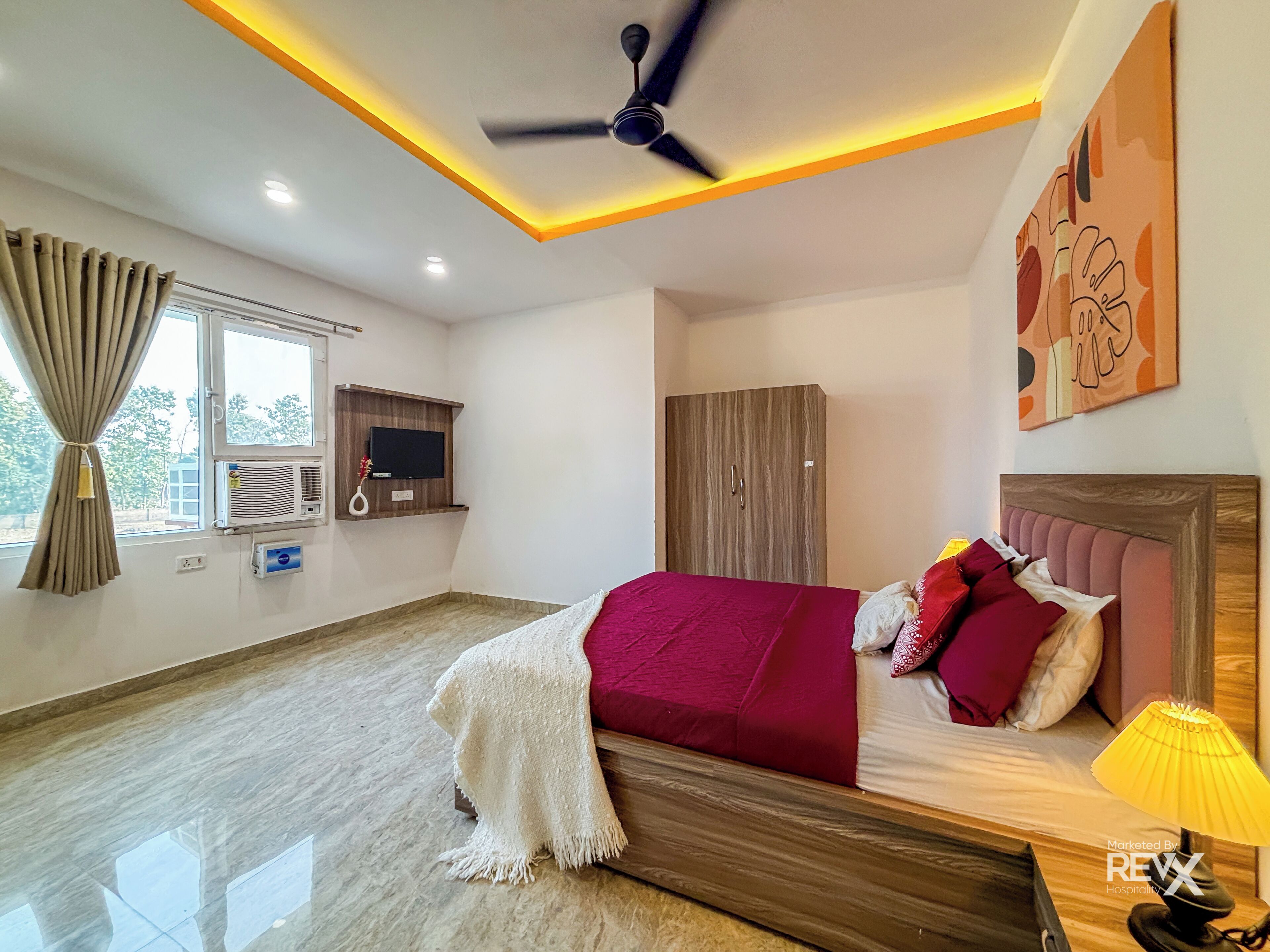 A modern bedroom with a bed, a ceiling fan, a TV, and a wardrobe.
