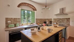 A kitchen with a large island, green window, tiled backsplash, and modern appliances. - Tenuta Pian Del Gallo, Greve in Chianti, Florence and Chianti (Greve in Chianti)
