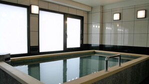 A rectangular indoor pool with a glass bottom, surrounded by a stone wall. - Hotel Alpha-One Yatsushiro (Yatsushiro)
