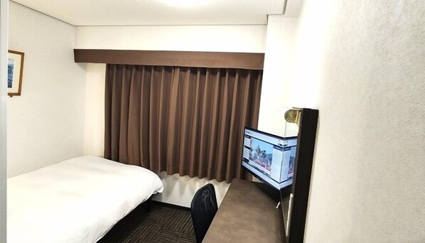 A hotel room with a bed, a desk with a computer, and a window with curtains. - Hotel Alpha-One Yatsushiro (Yatsushiro)