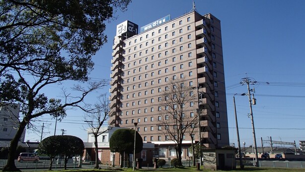 Un hôtel à plusieurs étages, doté d’une façade uniforme, de nombreuses fenêtres et de balcons.