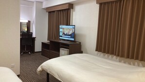 Une chambre d’hôtel équipée d’un lit, d’un bureau, d’une télévision et d’un mini-bar.