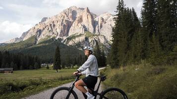A person on a mountain bike with a rocky mountain backdrop.