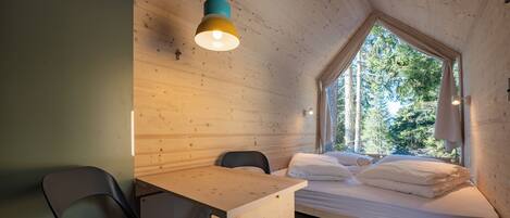 Une pièce de style cabane en bois, comprenant un lit, un bureau et une chaise.