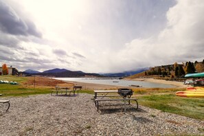 A lakeside picnic area with benches and kayaks. - Yacht Club 27 1 Bedroom Condo (Dillon)