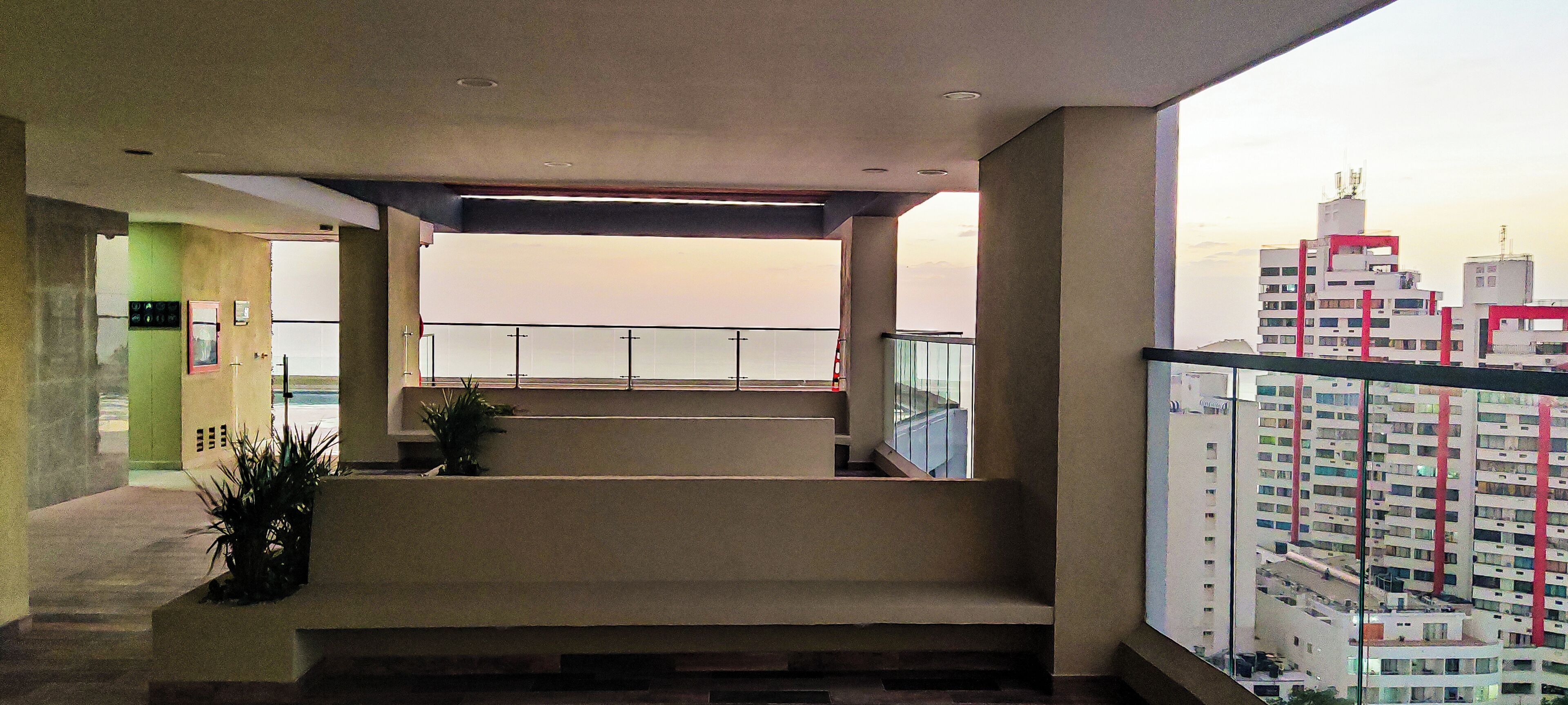 Ein modernes Hotelinterior mit Balkon, Treppe und Blick auf die Stadt.