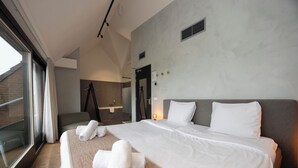 A modern hotel room with a large bed, a bathroom, and a balcony. - Het Wapen in Willemstad (Willemstad)