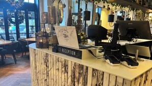 A reception desk with a laptop, a phone, and a coffee machine. - Het Wapen in Willemstad (Willemstad)