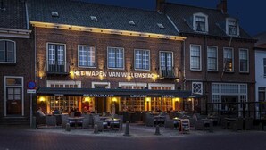 A brick building with a sign reading "HET WAPEN VAN WILLEMSTAD" and "TORRES RESTAURANT LOUNGE HOTEL". - Het Wapen in Willemstad (Willemstad)