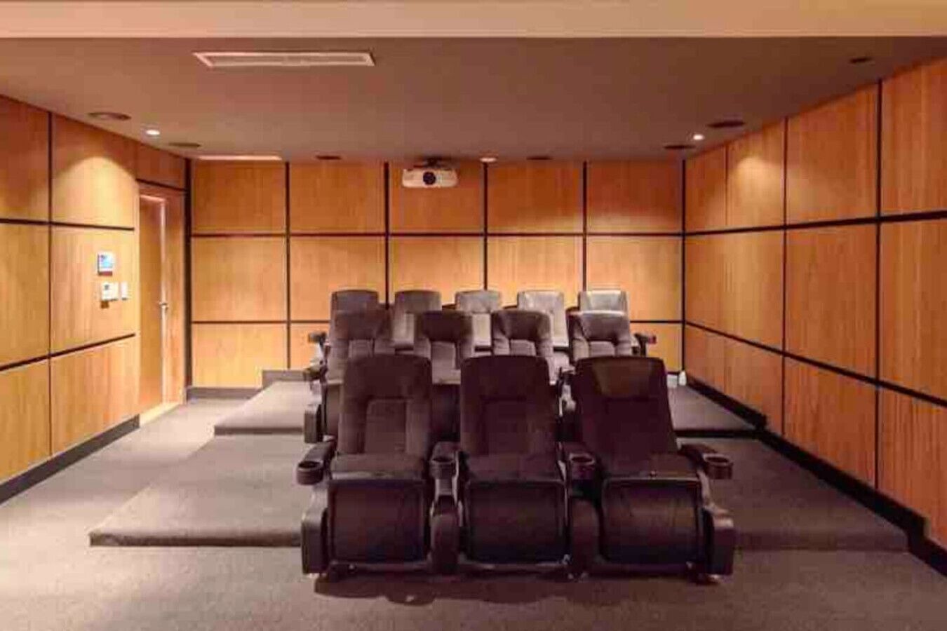 Un salón de conferencias con filas de sillas y una pantalla para proyector.