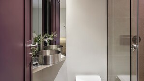 A modern bathroom with a glass shower enclosure, a vanity with two stainless steel sinks, and a mirror reflecting the room. - Presidential Suites by Athens Stay (Athens)