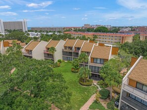 A residential complex with multiple apartment buildings, each featuring a balcony and a small garden area. - Modern Siesta Key Condo: Family-Friendly Retreat at Midnight Cove II 424D (Siesta Key)