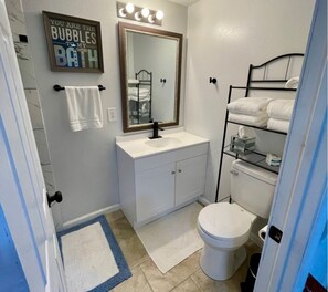 Een haardroger, handdoeken, zeep, toiletpapier