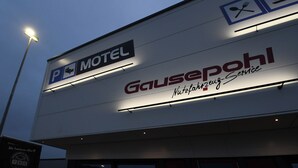 Un motel con un cartel que indica la disponibilidad de estacionamiento y un restaurante llamado 'Gausepohl' que ofrece servicio de buffet.