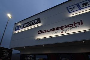 Um motel com placa indicando disponibilidade de estacionamento e um restaurante chamado "Gausepohl" que oferece serviço de buffet.