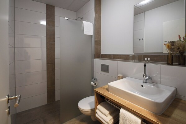 Un baño moderno con ducha, inodoro y lavabo.