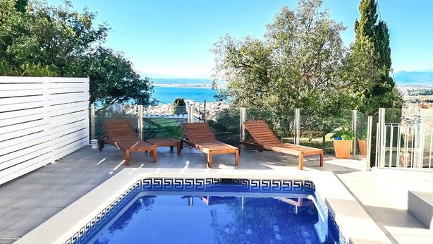 Ein Pool auf dem Dach mit Liegestühlen und Blick auf das Meer.
