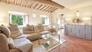 A spacious living room with a sofa set, a coffee table, and a modern cabinet. - La Querciola Castelfalfi Borgo (Castelfalfi)
