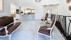 A spacious living area with a high ceiling, a dining area, and a kitchen in the background. - Family Villa with swimming pool tennis spa (Auribeau sur siagne)