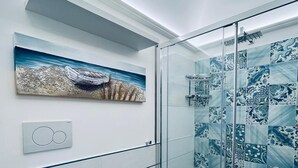 Une salle de bain moderne équipée de toilettes, d’un bidet et d’une douche à parois de verre.