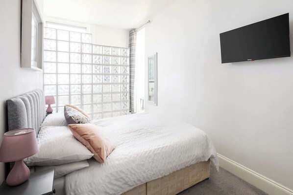 Desk, iron/ironing board, bed sheets