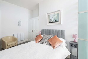 Escritorio, tabla de planchar con plancha y ropa de cama 