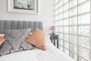 Escritorio, tabla de planchar con plancha, ropa de cama