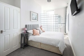 Escritorio, tabla de planchar con plancha y ropa de cama 