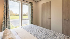 A bedroom with a bed, two wardrobes, and a window with curtains. - Host & Stay | Riverwood, Ashdown Retreat (Pickering)