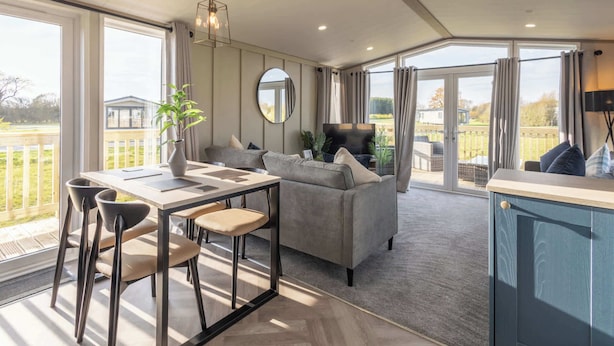 A spacious living area with a dining table, sofa, and a view of the outdoors. - Host & Stay | Riverwood, Ashdown Retreat (Pickering)